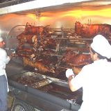 retirando los corderos asados del asador asado de bueyes y animales enteros para fiestas moka catering
